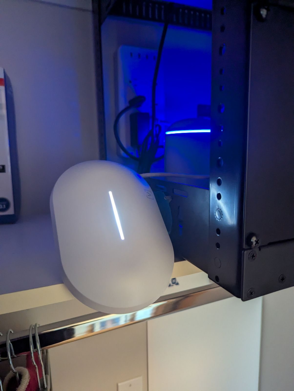 An Alta Labs Summit-A6 access point beneath the home's network rack in a closet