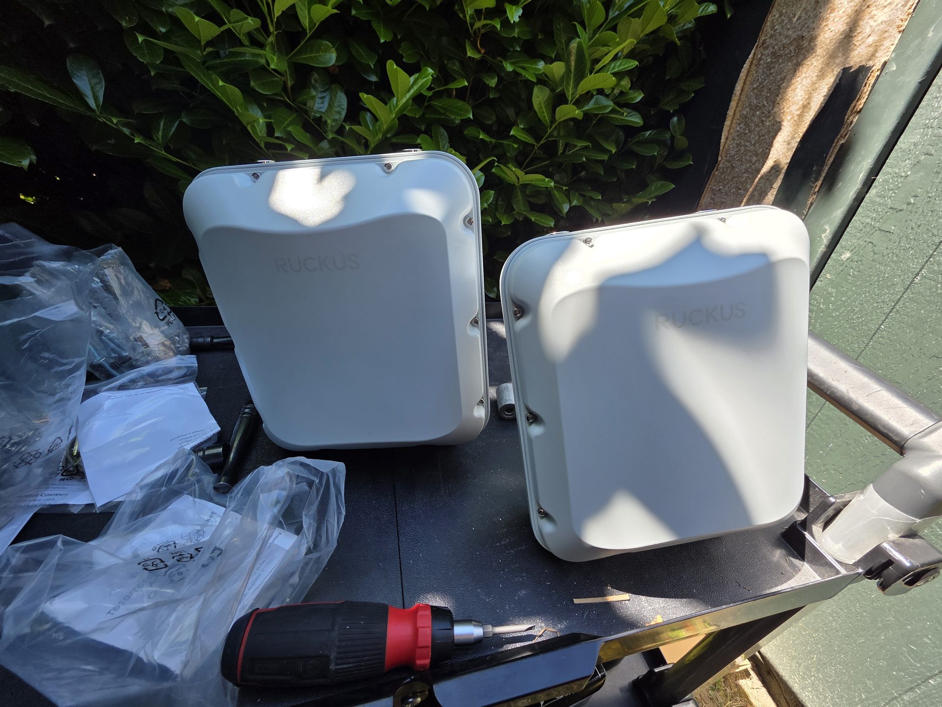 Two Ruckus outdoor access points on the work bench before mounting