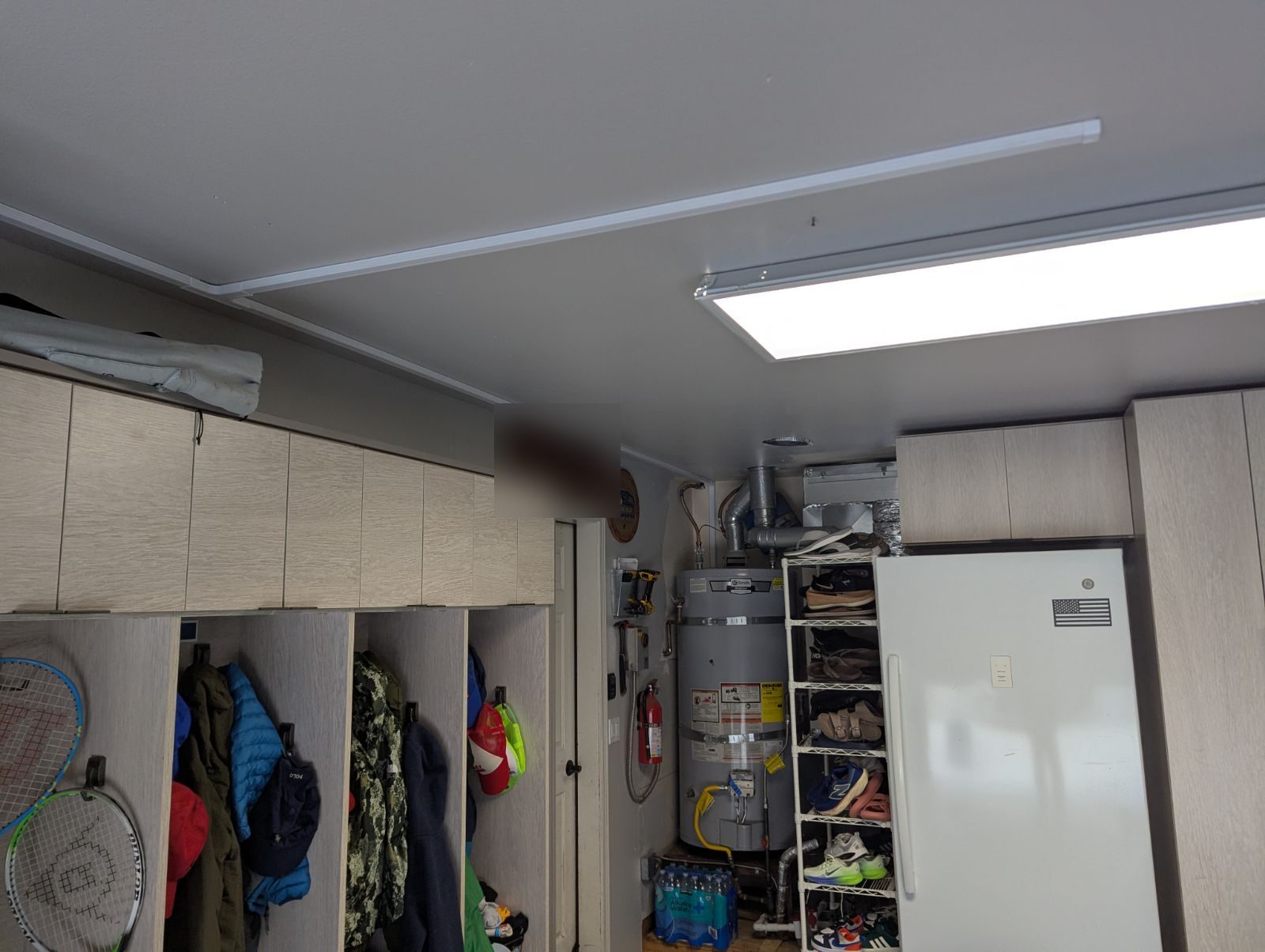 A white surface raceway running straight along a garage ceiling line to carry network cable